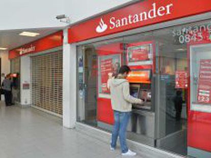 Un cliente retira dinero del cajero autom&aacute;tico de la sucursal de Banco Santander donde un grupo de &#039;hackers&#039; intent&oacute; perpetrar un robo.