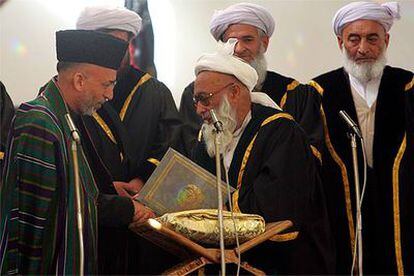 Karzai (izquierda) saluda al presidente de la Corte Suprema, Fazel Hadi Shinwari, durante la toma de posesión.