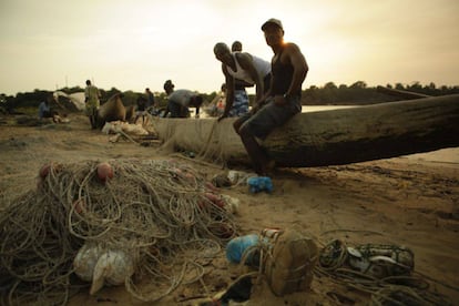 Unos pescadores arreglan las redes tras una jornada de pesca en Sierra Leona.