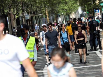 Varias personas pasean con y sin mascarilla, en el centro de Madrid.