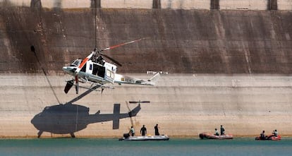 El helicóptero siniestrado es elevado por una grúa en la presa del embalse de Forata.