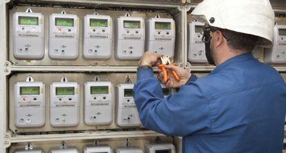 Un operario instala varios contadores de electricidad.