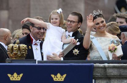 La princesa Estelle, izquierda, saluda a las multitudes con su padre el príncipe Daniel de Suecia y junto a la princesa heredera Victoria de Suecia afuera del Palacio de Estocolmo después de la ceremonia de la boda.