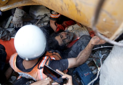 Un hombre es rescatado entre los escombros de un edificio en Gaza, este domingo.