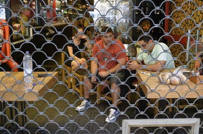 Un grupo de personas permanece dentro de un bar a la espera de que la policía les autorice a salir.