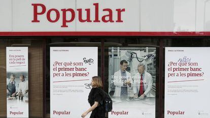 Una mujer pasa por delante de una oficina del Banco Popular, en Barcelona.