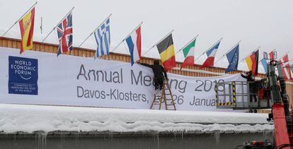 Dos operarios trabajan preparando el centro de congresos de Davos donde se celebrar&aacute; el Foro Econ&oacute;mico Mundial