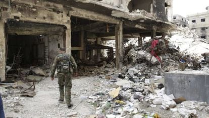 Un miliciano palestino camina entre los escombros del campo de refugiados de Al Yarmuk, en el sur de Damasco.