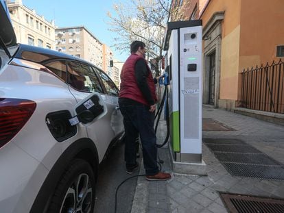 Un usuario en un punto de recarga de coches eléctricos, en la Ronda de Valencia (Madrid), en marzo de 2021.