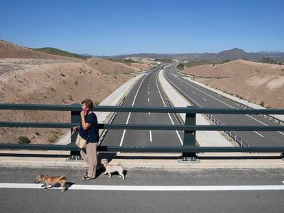 Una mujer pasea con sus perros sobre un puente en la autovía del Almanzora, en Almería.