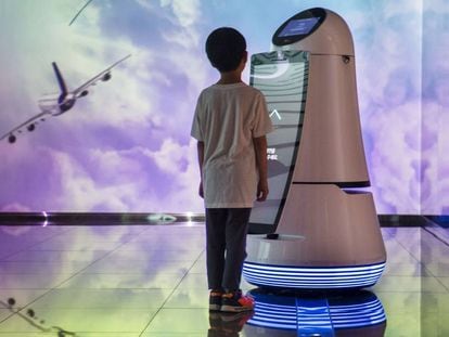 Un niño se  comunica con un robot en el aeropuerto internacional de Incheon, en Seúl. 