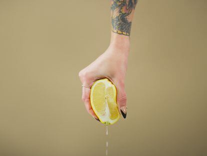 Una mujer exprime un limón.
