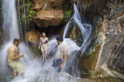 Varios visitantes disfrutan de una cascada en el cañón Clear Creek.