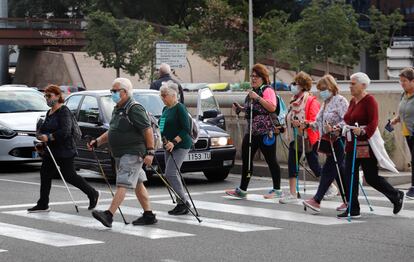 Varias personas cruzan un paso de peatones en una calle de Barcelona.