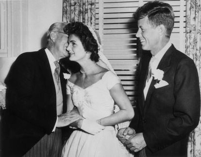 Joseph Kennedy (1888 - 1969) susurra algo al oido de a su nueva nuera Jacqueline Bouvier el día de su boda, mientras su esposo John F. Kennedy mira, sonrient. Fue en Newport, Rhode Island, el 12 de septiembre de 1953.