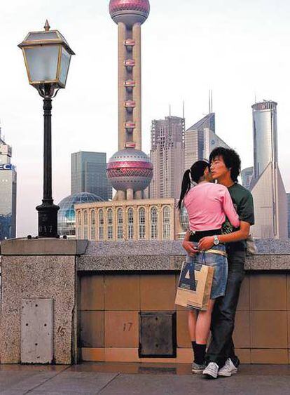 Una pareja se abraza en el Bund de Shanghai. El signo de los nuevos tiempos ha alcanzado a la economía o a los skylines, como este del Pudong, pero también a los más íntimos comportamientos sociales.