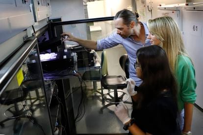 Los investigadores Nicholas Stroustrup, Andrea del Carmen y Natasha Oswal (en primer plano), en la "máquina de la longevidad" del Centro de Regulación Genómica, en Barcelona.