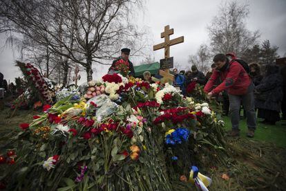 Varias personas depositan ramos de flores en el féretro de Boris Nemtsov durante la ceremonia religiosa celebrada este martes en el cementerio de Troyekúrovo, en Moscú.