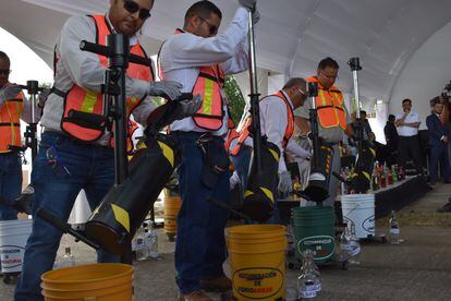 Personal de la policía federal mexicana y el consejo regulador de tequila destruyen botellas adulteradas. 