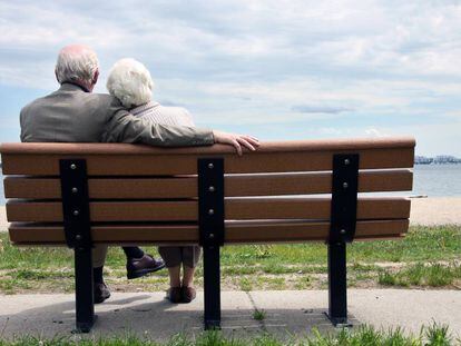 Pareja mayor sentado en el banco del parque.