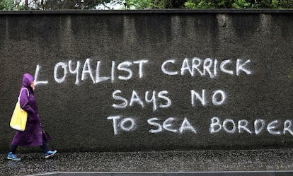 Una mujer pasa ante una pintada en contra de los controles aduaneros en el mar de Irlanda, el 3 de febrero de 2021 en Carrickfergus, Irlanda del Norte.