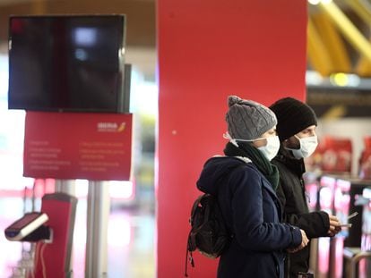 Dos pasajeros protegidos con mascarilla, este jueves en la Terminal 4 del Aeropuerto de Madrid.