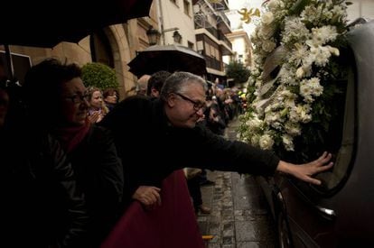 Un hombre toca el coche fúnebre llevando el ataúd del guitarrista flamenco español Paco de Lucía durante su funeral en su ciudad natal de Algeciras.