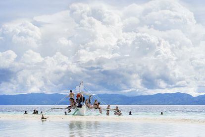 Turistas y locales descansan en un barco en las aguas tropicales de Cebu (Filipinas).