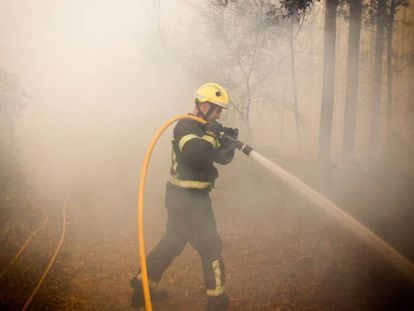 Un bombero trabaja este domingo en el incendio de Pazos de Bord&eacute;n (Pontevedra).