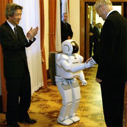 <i>Asimo</i> da la mano al primer ministro checo, Vladimir Spidla, para satisfacción de Koizumi.