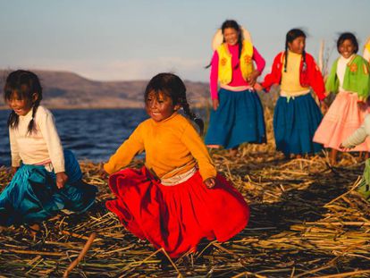 Un grupo de niñas de la comunidad Uros Titino juega a orillas del Lago Titicaca, a 14 kilómetros de la ciudad de Puno (Perú).