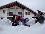 Tres niños se divierten en la nieve caída en Espinal (Navarra).