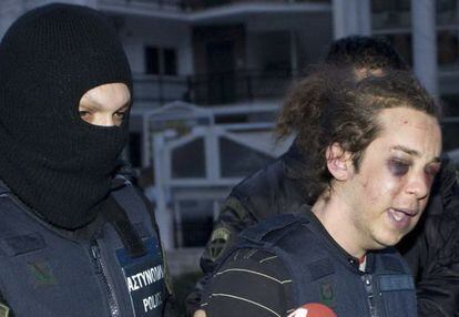 Un policía escolta a uno de los detenidos, el viernes en Kozani.