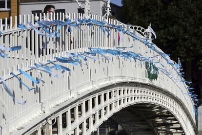 Lazos azules como homenaje a las víctimas de abusos sexuales por parte de la iglesia católica son atados al puente Ha'Penny de Dublín, el 25 de agosto de 2018. 