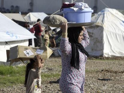 Una mujer yazid&iacute; y una ni&ntilde;a llevan en el campo de refugiados de Baharka, en Irak