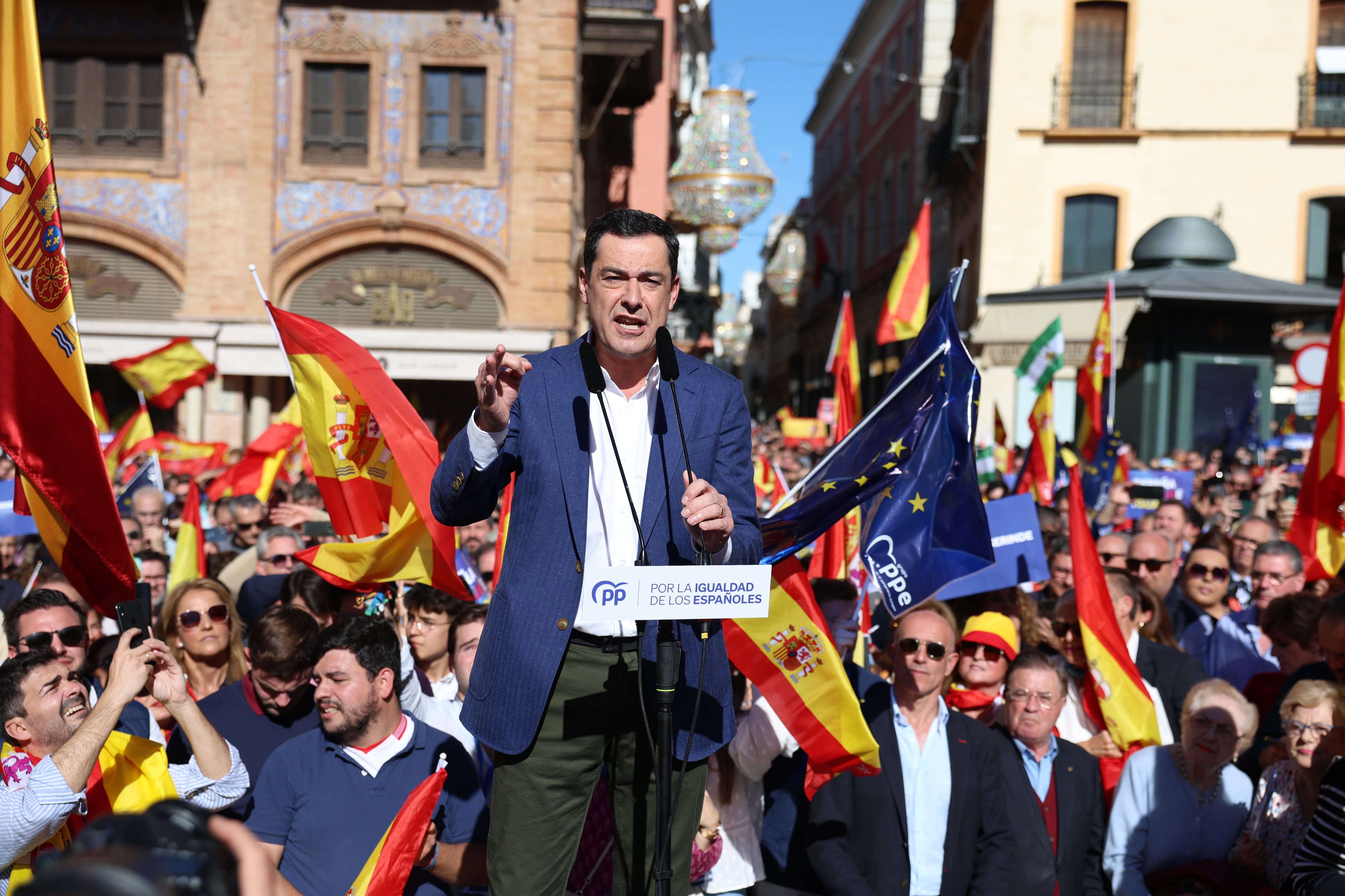 El presidente de la Junta de Andalucia, Juan Manuel Moreno, habla durante la concentración en contra de la amnistia en Sevilla.
