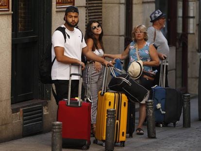 Varios turistas con maletas en el centro de Madrid.