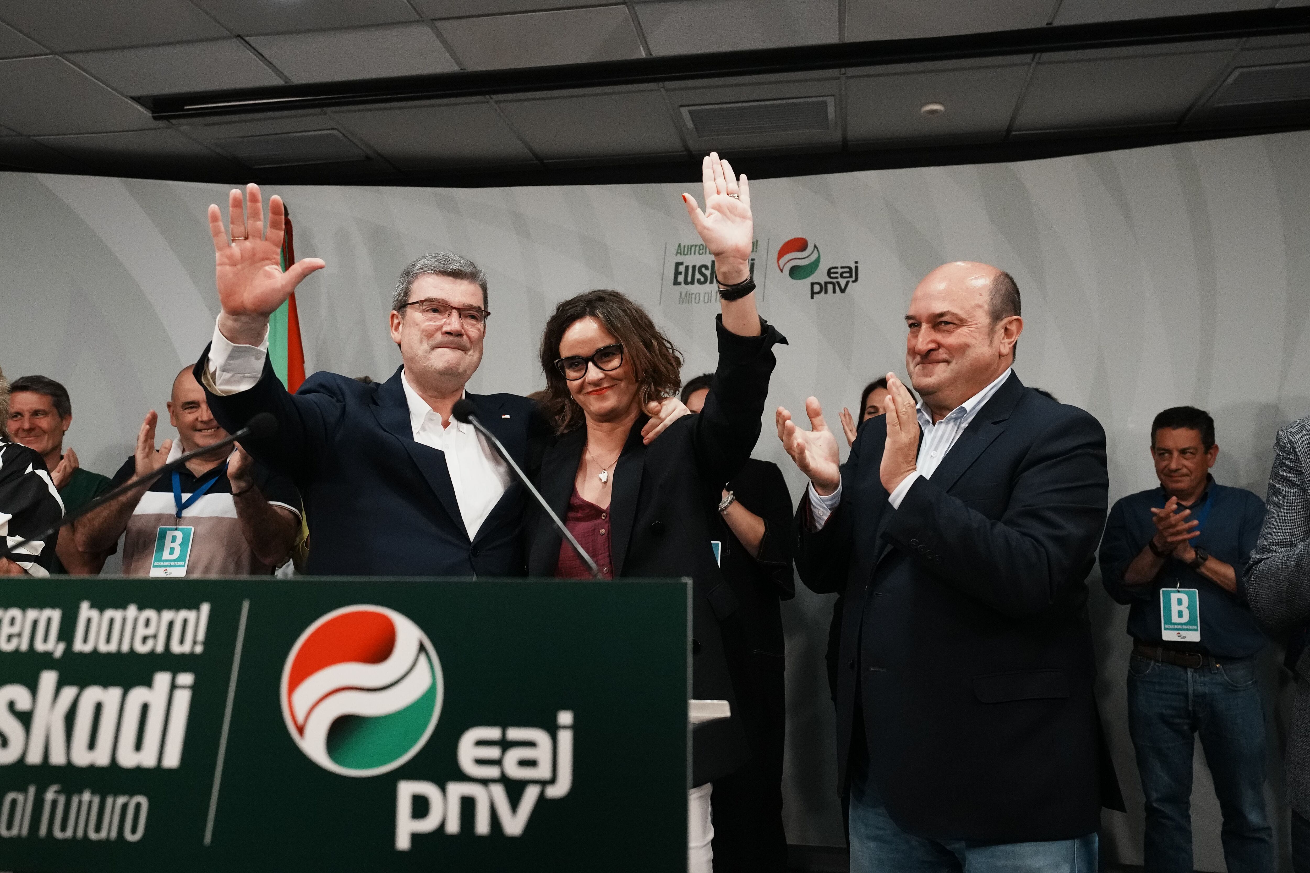 Desde la izquierda, el alcalde de Bilbao y candidato a la reelección por el PNV, Juan María Aburto; la candidata de PNV a diputada general de Bizkaia, Elixabete Etxanob, y el presidente del partido, Andoni Ortuzar, saludan durante el seguimiento de la jornada electoral.