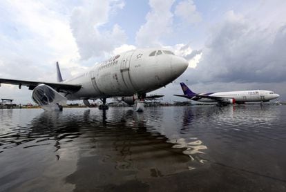 Los aviones permanecen estacionados en la pista inundada del aeropuerto de Don Mueang de Bangkok, que ha obligado a suspender sus operaciones