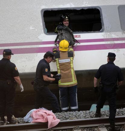 Equipos de emergencia rescatan carteras y mochilas para intentar identificar a las víctimas del accidente, 25 de julio de 2013.