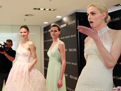 El modelo andrógino Andrej Pejic (derecha) posa vestido de novia junto a otras dos modelos en la Barcelona Bridal Week.