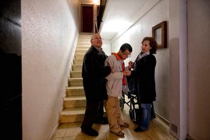 Los padres de Adrián Yepes le ayudan a bajar las escaleras en su casa de Cornellà.