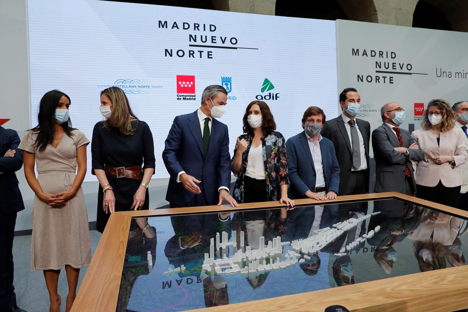 La presidenta de la Comunidad de Madrid, Isabel Díaz Ayuso (en el centro con camisa de flores), y el alcalde de Madrid, José Luis Martínez-Almeida (a la derecha) y otros altos cargos regionales durante la presentación de la maqueta del proyecto Madrid Nuevo Norte.