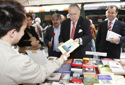El alcalde de Bilbao, Iñaki Azkuna, compra un libro en un puesto de la feria de la capital vizcaína.