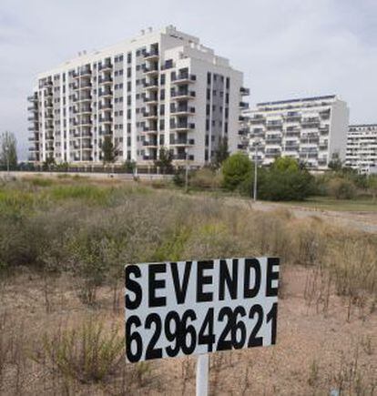 Un cartel de “Se vende” en medio de un solar en una urbanización paralizada.