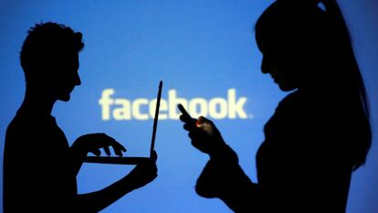 Dos personas, frente al logo de Facebook.