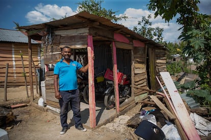 Un tablón en el piso con la marca "MF 011-5" en rojo le recuerda a Leocadio Guzmán dónde se erigía su vieja casa, derribada para abrir un camino hacia el muro que República Dominicana levanta en la frontera con Haití. En la imagen, Guzmán posa para un retrato frente a la choza donde se ha reubicado, en la provincia de Dajabón, el 20 de marzo de 2023.