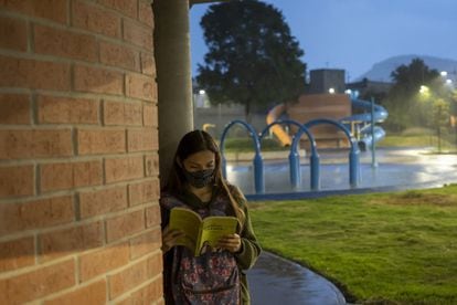 Una mujer lee bajo la lluvia en la escuela "Utopía Papalotl".