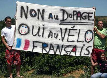 Aficionados despliegan una pancarta en la que se lee "No al dopaje; sí a la bici francesa" al paso del pelotón.