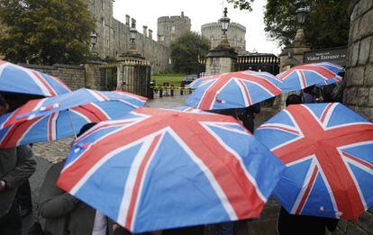 El público aguarda bajo la lluvia a las puertas del castillo de Windsor para intentar ver a los duques de Sussex y a su recién nacido.